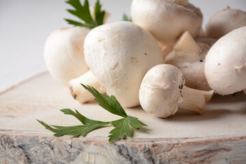 Fresh white champignon mushrooms on wooden board