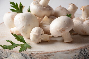 Fresh white champignon mushrooms on wooden board