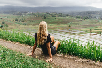 Freedom, travel,success concept.Woman sitting on rice terrace looking at the breathtaking view of...