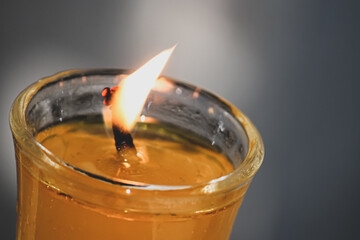 closeup of a burning candle in a glass in the dark
