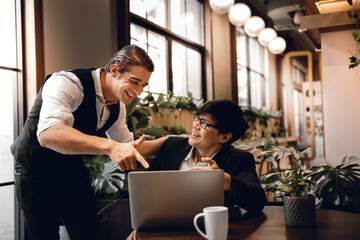 Two Businessman Working Together on Computer Laptop in Creative Workplace. Happy Business Partnership People