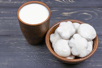 Gingerbread covered with icing with milk on a wooden table