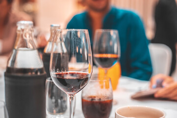 Glass of Red Wine on the food table with Lights Bokeh at night background.