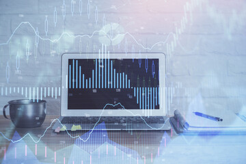 Stock market chart hologram drawn on personal computer background. Double exposure. Concept of...