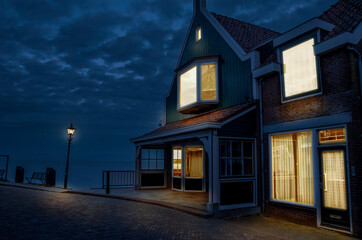 Wooden house illuminated at night with view of beautiful lake or sea