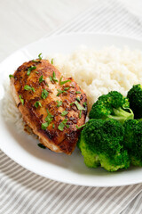 Homemade Chicken Breast, Rice and Broccoli on a white plate on a white wooden background, side view. Close-up.
