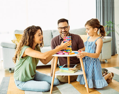 child daughter family happy mother father board game palying playing fun together girl cheerful home