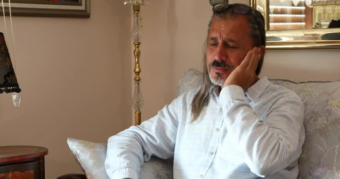 Man holding his aching ear, suffering from otitis