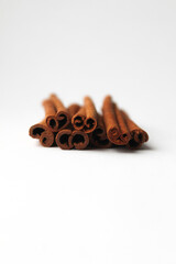 Loose cinnamon and cinnamon sticks on a white background. Cinnamon is used primarily for spices, imparting a spicy aroma to foods