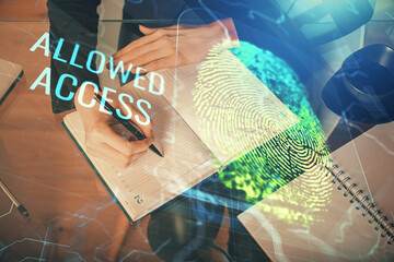 Blue fingerprint hologram over hands taking notes background. Concept of security. Double exposure