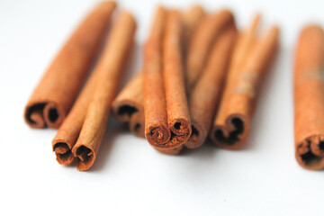 Loose cinnamon and cinnamon sticks on a white background. Cinnamon is used primarily for spices, imparting a spicy aroma to foods