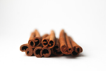 Loose cinnamon and cinnamon sticks on a white background. Cinnamon is used primarily for spices, imparting a spicy aroma to foods