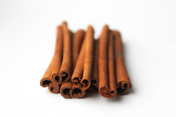 Loose cinnamon and cinnamon sticks on a white background. Cinnamon is used primarily for spices, imparting a spicy aroma to foods