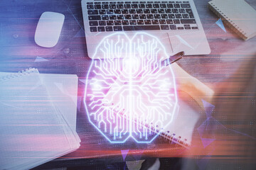 Multi exposure of writing hand on background with brain hologram. Concept of learning.