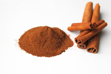 Loose cinnamon and cinnamon sticks on a white background. Cinnamon is used primarily for spices, imparting a spicy aroma to foods