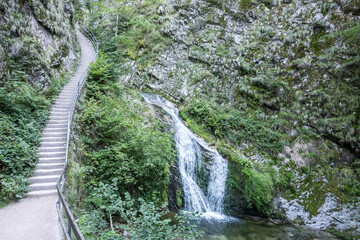 Fototapeta na wymiar steep staircase and Lierbach waterfall in woods of Black Forest, near Allerheiligen, Germany