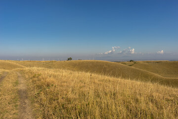 Obraz premium Blue sky with clouds and yellow hills