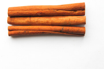 Loose cinnamon and cinnamon sticks on a white background. Cinnamon is used primarily for spices, imparting a spicy aroma to foods