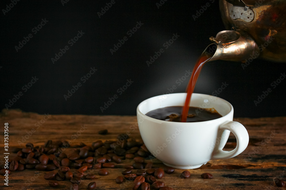 Wall mural Hot coffee in a white cup on a wooden table