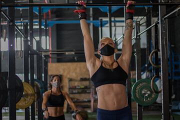 Chicas con mascarilla en un gimnasio realizando Cross training