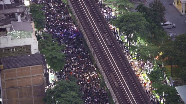 Aerial top view of flash mobs protesters demonstration rally on street road against government, crowd of people in Bangkok City, Thailand in public for democracy. Politics concept. Insurrection.