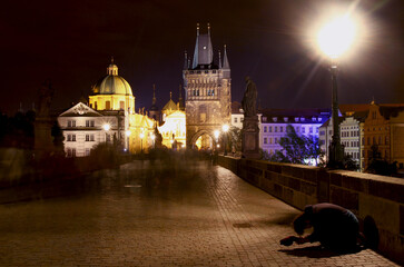 Charles bridge - Prague, Czech Republic:  Night shot long exposure with blurred people and a beggar waiting for money