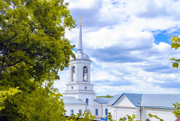Church steeple Orthodox monastery. A tower with domes, a cross and a tree against a blue sky. The Church belfry.