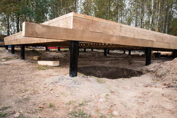 Construction site. The basis of a wooden house. Construction of the pile.