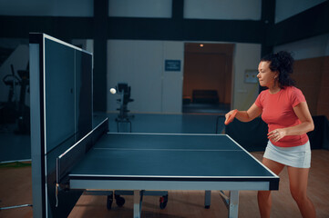 Woman hits the ball at the wall, table tennis