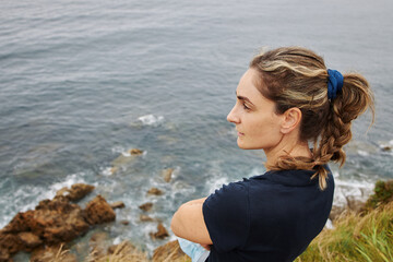 Top view of girl looking to the ocean on a cliff
