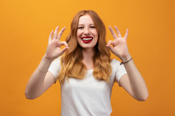 Happy girl is showing OK a two handed gesture. Human emotions concept