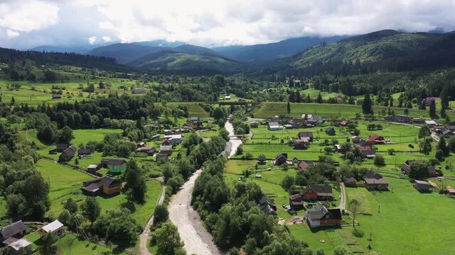 Carpathian Mountains with River and Beautiful vintage wooden houses aerial view.