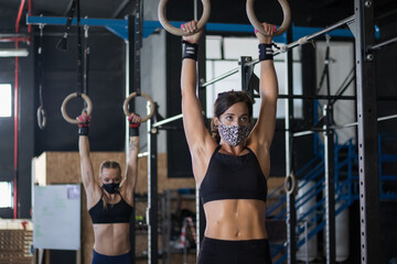 Chica realizando Cross training, haciendo ejercicios de anillas 
