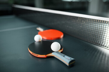 Ping pong rackets and ball at the net closeup