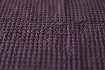 Textured purple linen waffle cotton towel. close up. Natural linen material violet towel pattern background.