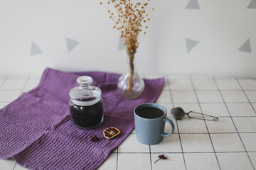Morning tea with homemade oatmeal cookies on kitchen table with purple linen towel. Breakfast scene in the kitchen. copy space
