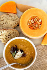 Pumpkin soup and white bread with raw pumpkin.