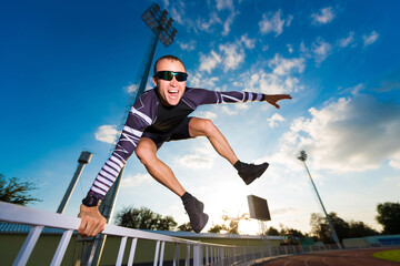 Athlete jumping over the fence at the stadium