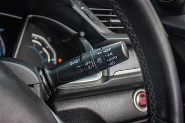 Switch off lights in a car. close-up Car integrated turning indicator with headlight switch toggle.