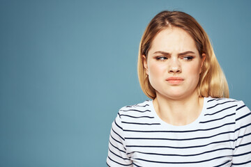 Upset woman emotions displeasure gestures with hands blue background