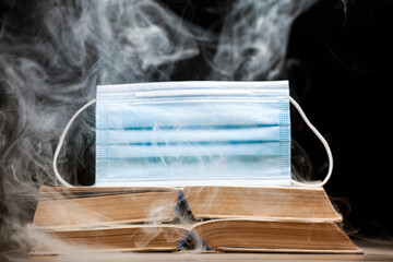 image of book mask smoke dark background 