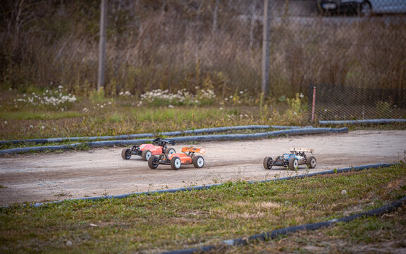 Three RC buggies racing on an outdoor offroad track