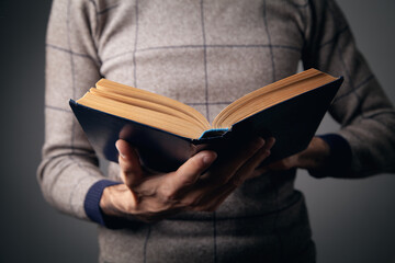 young man holding a book in his hand