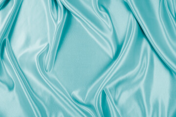 Obraz premium Photography of beautiful wavy turquoise silk satin luxury cloth fabric, abstract background design.