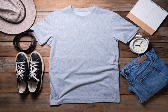 Mockup of a gray t-shirt blank shirt template with accessories on the table background, lifestyle and travel concept