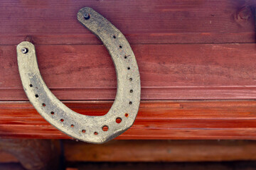 An old horseshoe from a horse's hoof hangs on the wall. Background. Copy space.