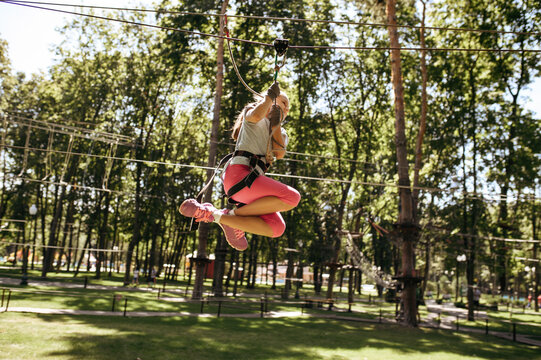 Little brave girl on zipline in rope park