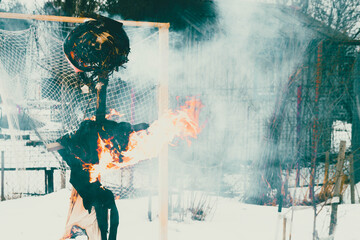 A woman doll blackened by fire. Fire burns the fabric.
