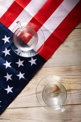 Two glasses opposite each other on background of American flag. The concept of battling in US Presidential Election