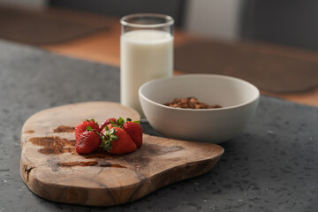 Organic oat granola with strawberry and yogurt on concrete background